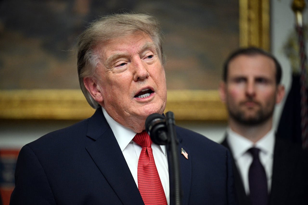 U.S. President Donald Trump speaking in front of a microphone.