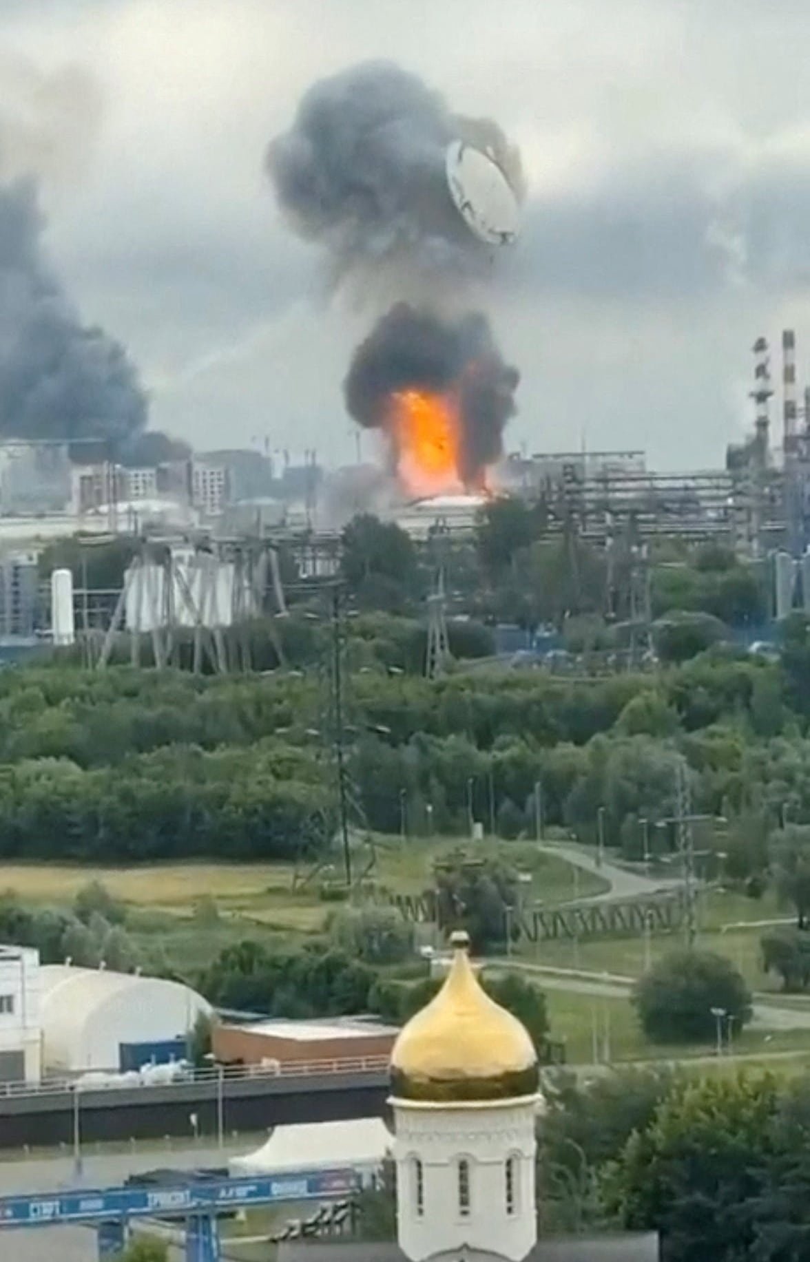An explosion occurs at a distant point on a city skyline.