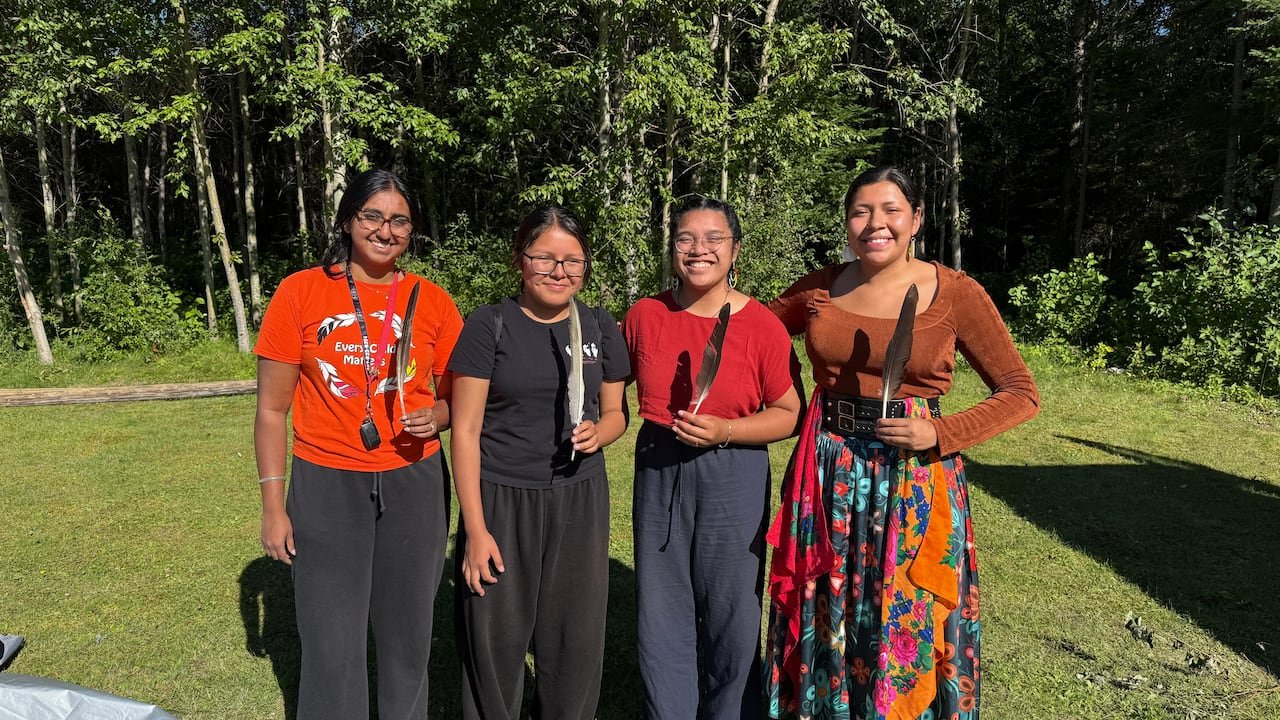 Tisha with members of the collective holding feathers