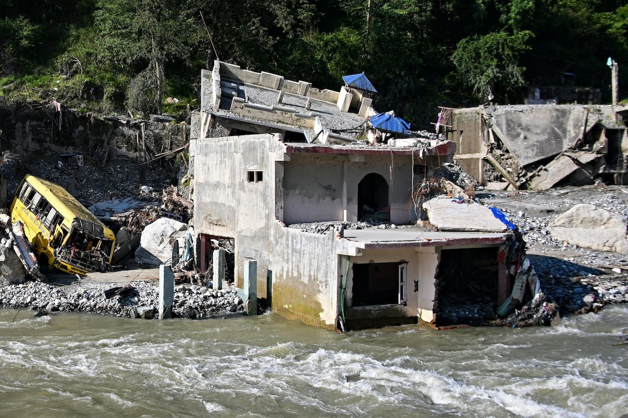 A concrete structure is shown damaged with waters surrounding it in a remote setting.