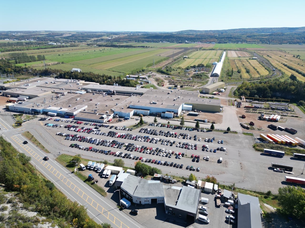 An aerial photograph of a large factory and parking lot.