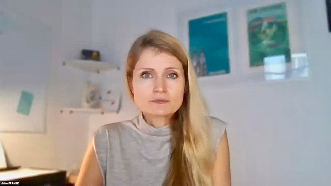 A woman with blond hair in a grey shirt.