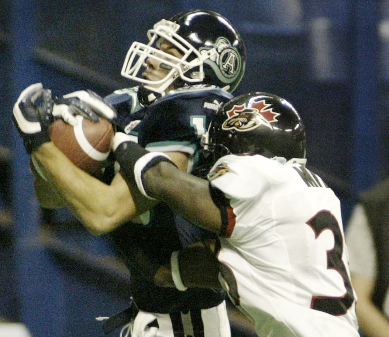 One football player tackles another in a game in the early 2000s.