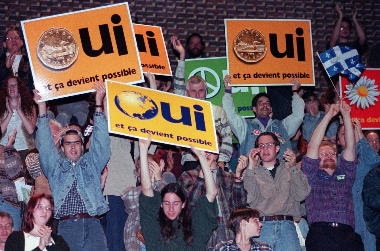 default-7 Supporters cheer, holding up signs that say yes.
