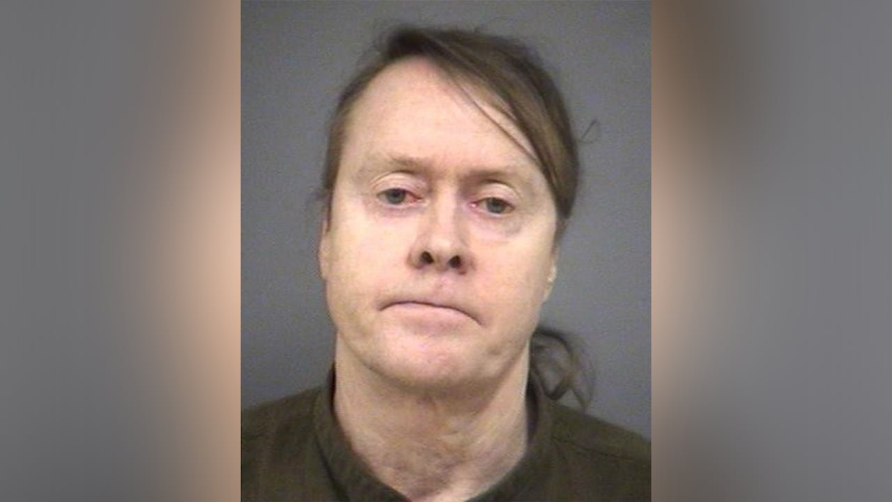 A man with long dark hair in a dark shirt